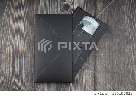 Black VHS video tape cassette with blank label isolated on wooden background 130190823