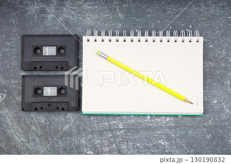 Retro audio cassette tape from the 80s and 90s on a white background. blank playlist on notebook. Top view, nostalgic concept. Retro audio cassette tape from the 80s and 90s on a white background. blank playlist on notebook. Top view, nostalgic concept. 130190832
