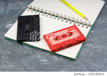 Retro audio cassette tape from the 80s and 90s on a white background. blank playlist on notebook. Top view, nostalgic concept. 130190833