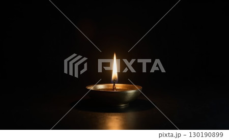 Minimalist Brass Diya Lighting Against Pure Black Background Symbolis. Dashahra, India. Minimalist Brass Diya Lighting Against Pure Black Background Symbolis. Dashahra, India. 130190899