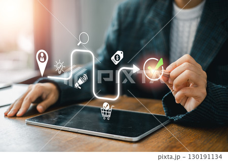 Illustration of a customer journey concept with digital icons and a business professional interacting with a tablet. Illustration of a customer journey concept with digital icons and a business professional interacting with a tablet. 130191134