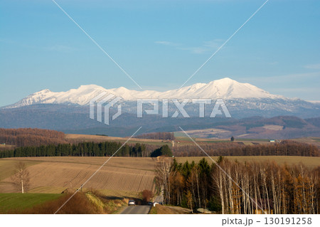 秋の丘陵畑作地帯と冠雪の山並み 大雪山 秋の丘陵畑作地帯と冠雪の山並み 大雪山 130191258