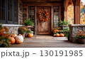 Traditional American porch adorned for Thanksgiving with pumpkins and a colorful wreath 130191985