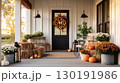 Charming front door entrance decorated for Thanksgiving with pumpkins and flowers in a cozy fall setting 130191986