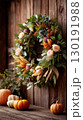 Warm Thanksgiving entryway decorated with a beautiful fall wreath and pumpkins 130191988