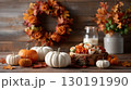 Warm Thanksgiving entryway decorated with pumpkins, harvest wreath, and autumn leaves for family gatherings 130191990