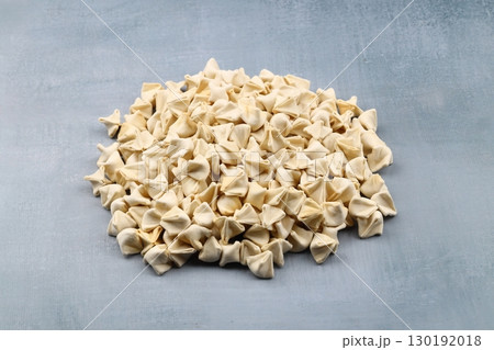 handmade manti (turkish ravioli type dumplings) on grey background, before cooking 130192018
