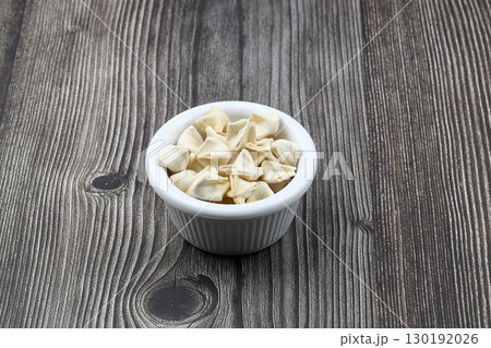 handmade manti (turkish ravioli type dumplings) on wooden   bowl, before cooking 130192026