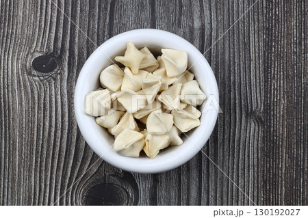 handmade manti (turkish ravioli type dumplings) on wooden bowl, before cooking handmade manti (turkish ravioli type dumplings) on wooden bowl, before cooking 130192027