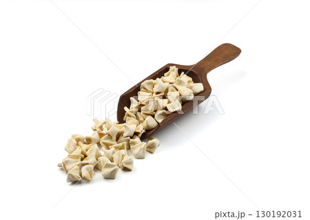 handmade manti (turkish ravioli type dumplings) on wooden scoop, before cooking. isolated on white background handmade manti (turkish ravioli type dumplings) on wooden scoop, before cooking. isolated on white background 130192031