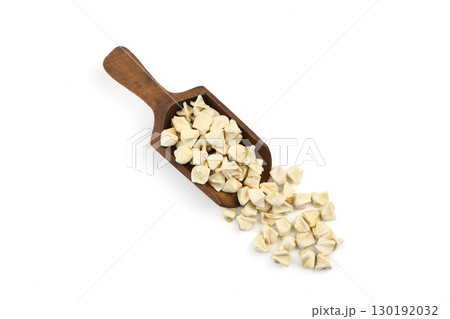 handmade manti (turkish ravioli type dumplings) on wooden scoop, before cooking. isolated on white background handmade manti (turkish ravioli type dumplings) on wooden scoop, before cooking. isolated on white background 130192032