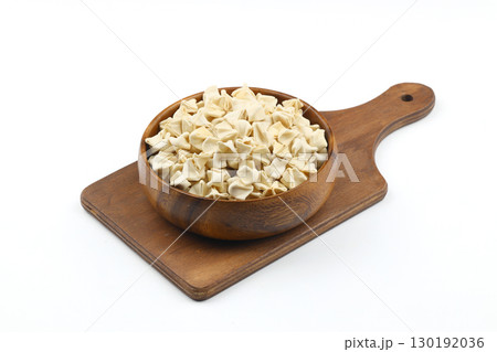 handmade manti (turkish ravioli type dumplings) on wooden bowl, before cooking. isolated on white background. handmade manti (turkish ravioli type dumplings) on wooden bowl, before cooking. isolated on white background. 130192036