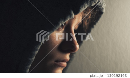 Contemplative Side Profile of a Hooded Individual in Soft Lighting Contemplative Side Profile of a Hooded Individual in Soft Lighting 130192168