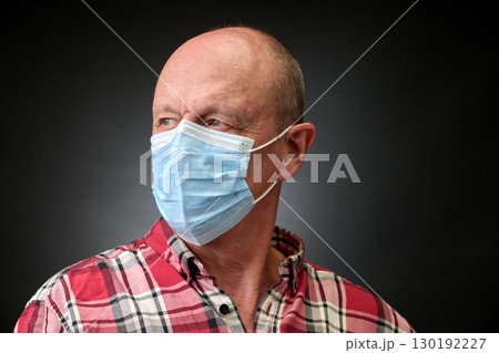 Closeup portrait of a elderly man in studio wearing a facial mask 130192227