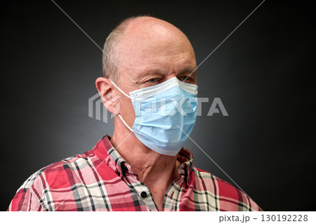 Closeup portrait of a elderly man in studio wearing a facial mask 130192228