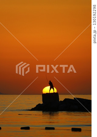 Tourists on holiday in the famous resort town of Bodrum spend time fishing at sunset. 130192298