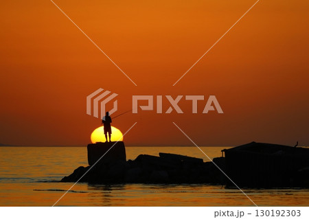 Tourists on holiday in the famous resort town of Bodrum spend time fishing at sunset. 130192303