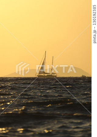 Alone sailboat at sunset. Atmospheric seascape with orange sun. Alone sailboat at sunset. Atmospheric seascape with orange sun. 130192385