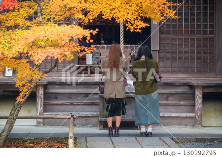 Japanese women pray at Nanzen-ji temple shrine with fall colors, Kyoto 130192795