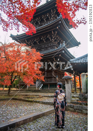 Lady in Kimono view Shinnyodo pagoda by fall leaf colors, Kyoto 130192813