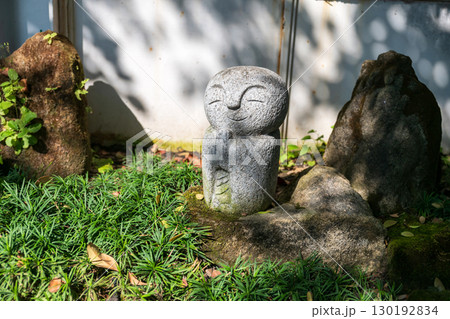 Smiling Jizo Buddha statue on spring Japanese garden 130192834