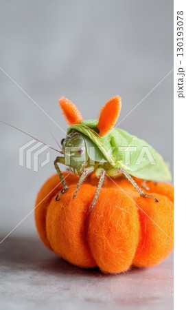 Grasshopper dressed as a bunny on orange pumpkin Grasshopper dressed as a bunny on orange pumpkin 130193078
