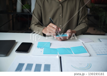 Businessman reading report in office desk analyze data for plan project 130193181