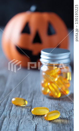 Colorful capsules and Halloween pumpkin decoration Colorful capsules and Halloween pumpkin decoration 130193225