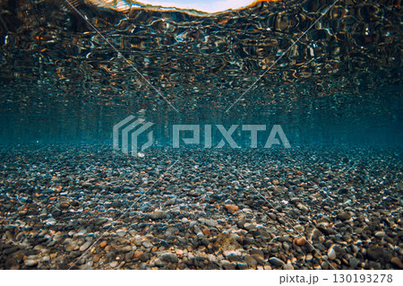 Underwater scene with stones bottom and reflection on surface in crystal sea. Water background. Underwater scene with stones bottom and reflection on surface in crystal sea. Water background. 130193278