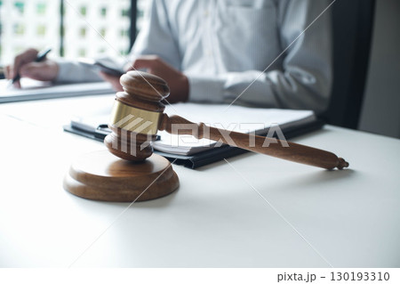 Legal justice man working on desk reading supportive documents to determine the consulting case 130193310