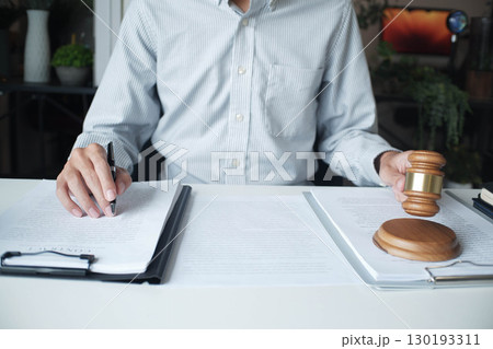 Legal justice man working on desk reading supportive documents to determine the consulting case 130193311