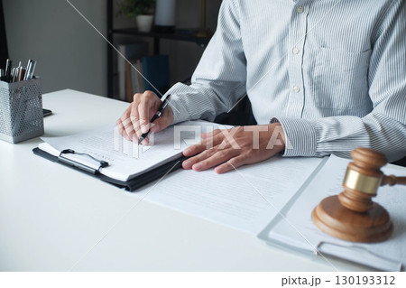 Legal justice man working on desk reading supportive documents to determine the consulting case 130193312