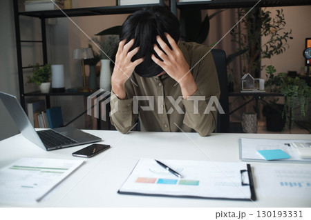 Overworked stressed businessman has headache pain while working in office. 130193331