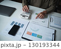 Businesswoman, entrepreneur, accountant working on financial report on desk using calculator. 130193344