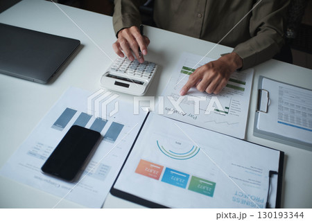 Businesswoman, entrepreneur, accountant working on financial report on desk using calculator. 130193344