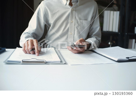 Legal justice man working on desk reading supportive documents to determine the consulting case 130193360