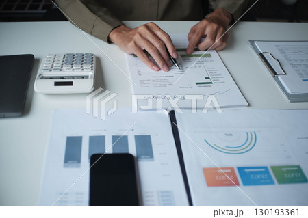 Businessman reading report in office desk analyze data for plan project 130193361