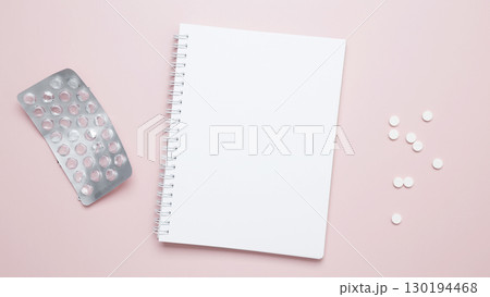 Concept of medicine, healthcare, and pharmaceutical industry. Blister of tablets and blank notebook Concept of medicine, healthcare, and pharmaceutical industry. Blister of tablets and blank notebook 130194468