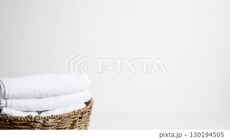 Household cleaning and hygiene concept packaging. Basket filled with clean white towels in a neat arrangement 130194505