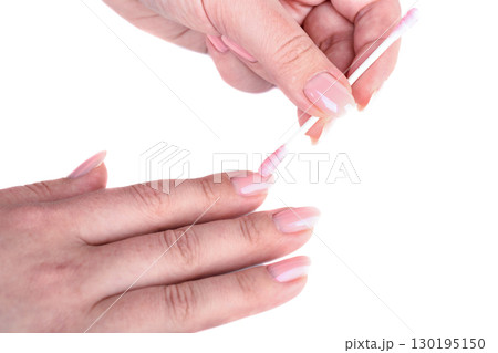 Cleaning women's nails with manicure using a cotton swab. 130195150