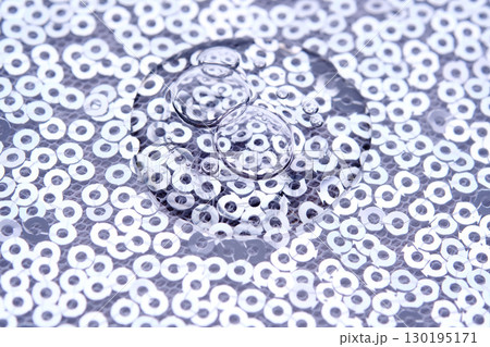 A drop of makeup on a background of silver sequins. A drop of makeup on a background of silver sequins. 130195171