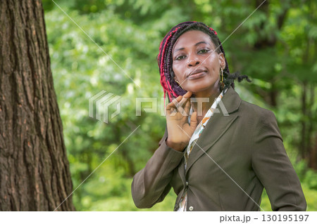 African businesswoman posing outdoors in natural forest setting professional portrait among trees 130195197
