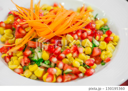 pomegranate corn and carrot salad in plate, close-up, selective focus 130195360