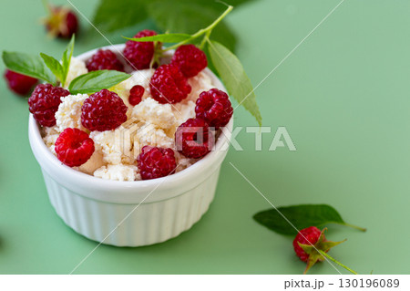 Fresh cottage cheese with red raspberries and greens in a bowl Fresh cottage cheese with red raspberries and greens in a bowl 130196089