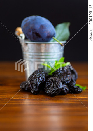 Fresh plum and dried prunes with rustic wooden table Fresh plum and dried prunes with rustic wooden table 130196112