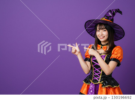 紫背景に魔女の仮装をする女性 130196692