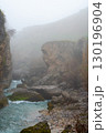 Rocky gorge with a turquoise river in misty weather 130196904