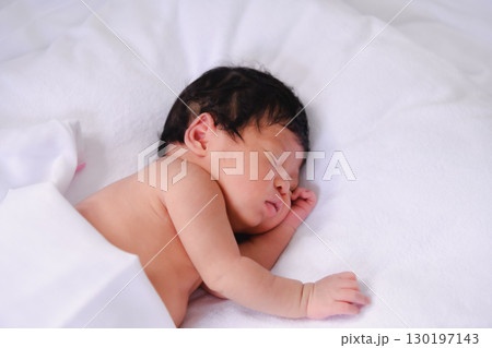 A peaceful newborn baby sleeping soundly on a soft blanket, embodying innocence and tranquility. A peaceful newborn baby sleeping soundly on a soft blanket, embodying innocence and tranquility. 130197143