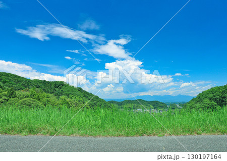 夏の青空と緑の草原　〜大塩ダムの天端道路から下流面方向を臨む〜 130197164