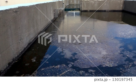 Mud Accumulation on Treatment Plant Water Surface in Industrial Area During Daylight Hours Mud Accumulation on Treatment Plant Water Surface in Industrial Area During Daylight Hours 130197345